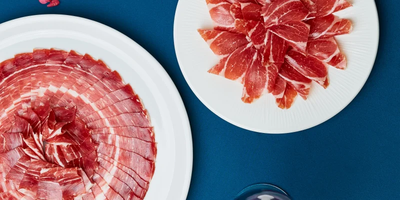Bodegón de dos platos de jamón de bellota 100% ibérico